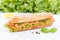 Sub sandwich whole grains baguette with smoked salmon fish on wooden board