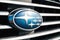 Subaru emblem on a radiator grill. Silver stars on a blue background. Side view