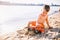 Subject construction and heavy industry. Abstraction child boy playing on the sand near the river in the summer toy red tractor