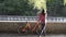 Subject ecological bicycle transport. A young caucasian woman in jeans and a shirt student sits resting in a park near