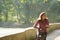 Subject ecological bicycle transport. Young Caucasian woman riding on a dirt road in a park near a lake renting an orange-colored