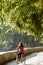 Subject ecological bicycle transport. Young Caucasian woman riding on a dirt road in a park near a lake renting an orange-colored