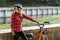 Subject ecological mode of transport bicycle. Beautiful young kasazy woman wearing a blue helmet and long hair poses standing next