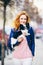 Subject man and dog. young red-haired Caucasian woman with freckles on face holds black and white shaggy chihuahua breed dog. The