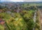 Suburb of an industrial town with meadows and lawns in northern Germany, straightened stream in the foreground, chimneys and