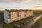 Suburb landscape, apartment building. Parked cars along bad road on spring day on blue sky copy space background