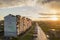 Suburb landscape, apartment building. Parked cars along bad road on spring day on blue sky copy space background