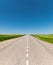 Suburban empty road asphalt surrounded by trees and grass. The concept of transportation and travel. Background green