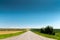 Suburban empty road asphalt surrounded by trees and grass. The concept of transportation and travel. Background green