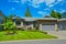 Suburban family house with nice lawn, wide garage door, and concrete driveway