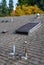 Suburban house rooftop, asphalt shingles, skylight with cover, roof vents