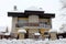 Suburban house with stone facade front covered with snow