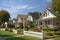 suburban neighborhood with front porches, picket fences, and rolling lawns