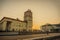 Suburban railway station building with clock tower  in the rays of the rising sun.