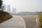 Suburban riverside fenced planked platform along curving path at