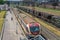 Suburban train stands at station in the industrial zone