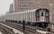 subway train on elevated track in the bronx with apartment buildings in the background (above ground metro line in nyc)