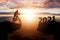 Success 2021 new year concept. Silhouette of cyclist riding between 2020 years with sunset