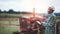 Success african male farmer in checkered shirt and straw hat holding digital tablet with smile and happy while standing near truck