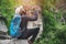 Success african man traveler sitting on the cliff with backpack