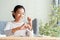 Success Asian young girl is putting coins in a piggy bank at home, Asia of child happy smile, retirement, finance and saving money