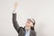 Success in business or career. Enthusiastic businesswoman with raised arms cheering in isolated on grey background