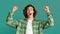 Success and celebration. Triumphant young guy showing victory gesture on turquoise background