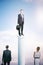 Success concept with businessman on column and other people