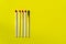 Success, defeat, achievement. The concept of happiness. Matches on a yellow background. Burnt dark match among normal matches.