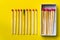 Success, defeat, achievement. The concept of happiness. Matches on a yellow background. Burnt dark match among normal matches.