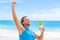 Success fitness man runner drinking protein shake muscle gain or weight loss goal winning. Running athlete on beach with healthy