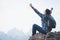 Success man hiker holding and drink water at cliff edge on mountain top. Concept of traveling and hiking adventures