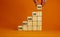 Success onboarding process symbol. Wooden cubes stacking as step stair on orange background, copy space. Businessman hand. Word `