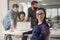 Success is one thing we know best. Portrait of a designer sitting in an office with her colleagues blurred out.