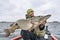 Success pike fishing. Happy fisherman with big fish trophy at boat