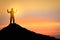 Success and winner concept, Silhouette of man standing and showing hand to celebrate in sunset and twilight..