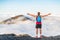 Success winner fitness man reaching top of mountain peak winning with open arms in freedom. Hiker or trail running runner