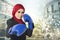 Successful and aggressive young muslimah businesswomen with boxing glove over abstract double exposure background