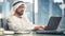 Successful Arab Businessman in Glasses and White Traditional Outfit Sitting in Office and Working