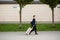 Successful asian businessman near airport and bus station goes with suitcases serious tourist looking at camera