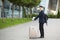 Successful asian businessman near airport and bus station goes with suitcases serious tourist looking at camera