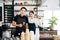 Successful Asian young male and female barista cafe entrepreneur holding coffee filter and standing inside the coffee counter bar