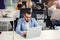 Successful bearded businessman in glasses and in blue suit works with laptop in modern office.