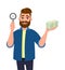 Successful bearded young man showing/holding magnifying glass and cash, money, currency notes in hand. Search, find, discovery.