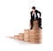 Successful business man sitting on money stairs
