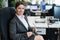 Successful business woman sitting at her desk in the office with glasses in her hands