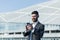 Successful businessman with beard uses phone outside office