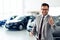 Successful businessman in a car dealership - sale of vehicles to customers