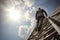 Successful Businessman Climbing High Ladder against Concrete Wall, Gazing at the Expansive Sky.