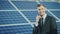 Successful businessman talking on the phone on the background of a solar power station